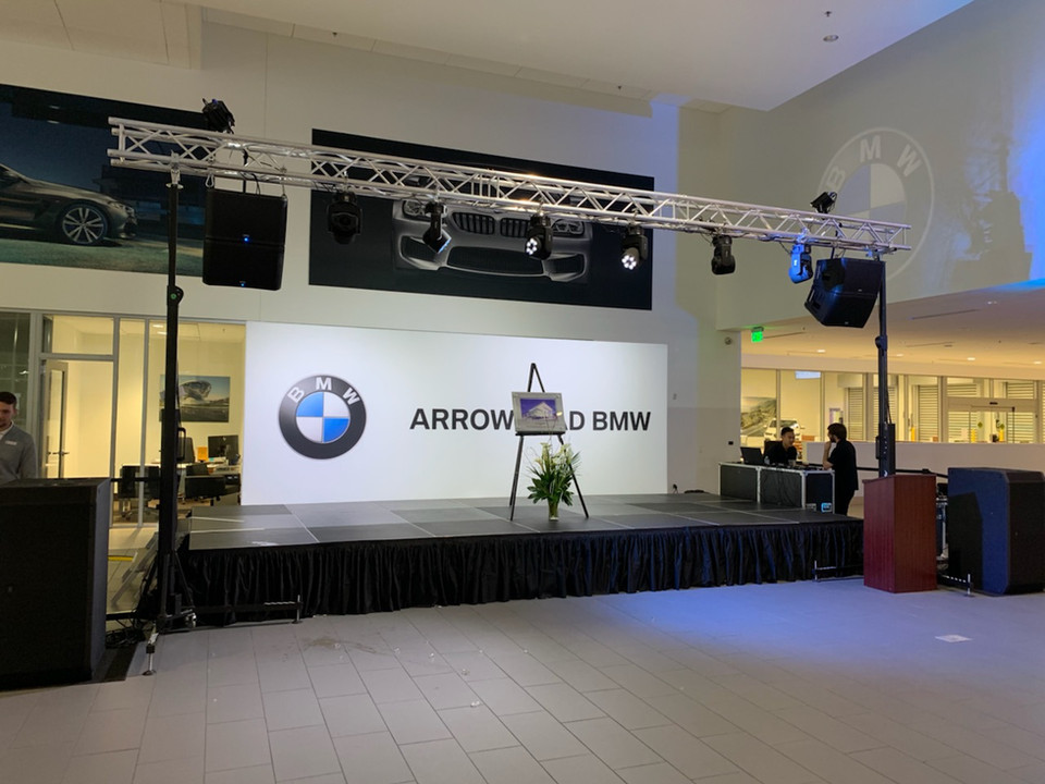 BMW event at their dealership with truss, lighting, stage, and audio equipment